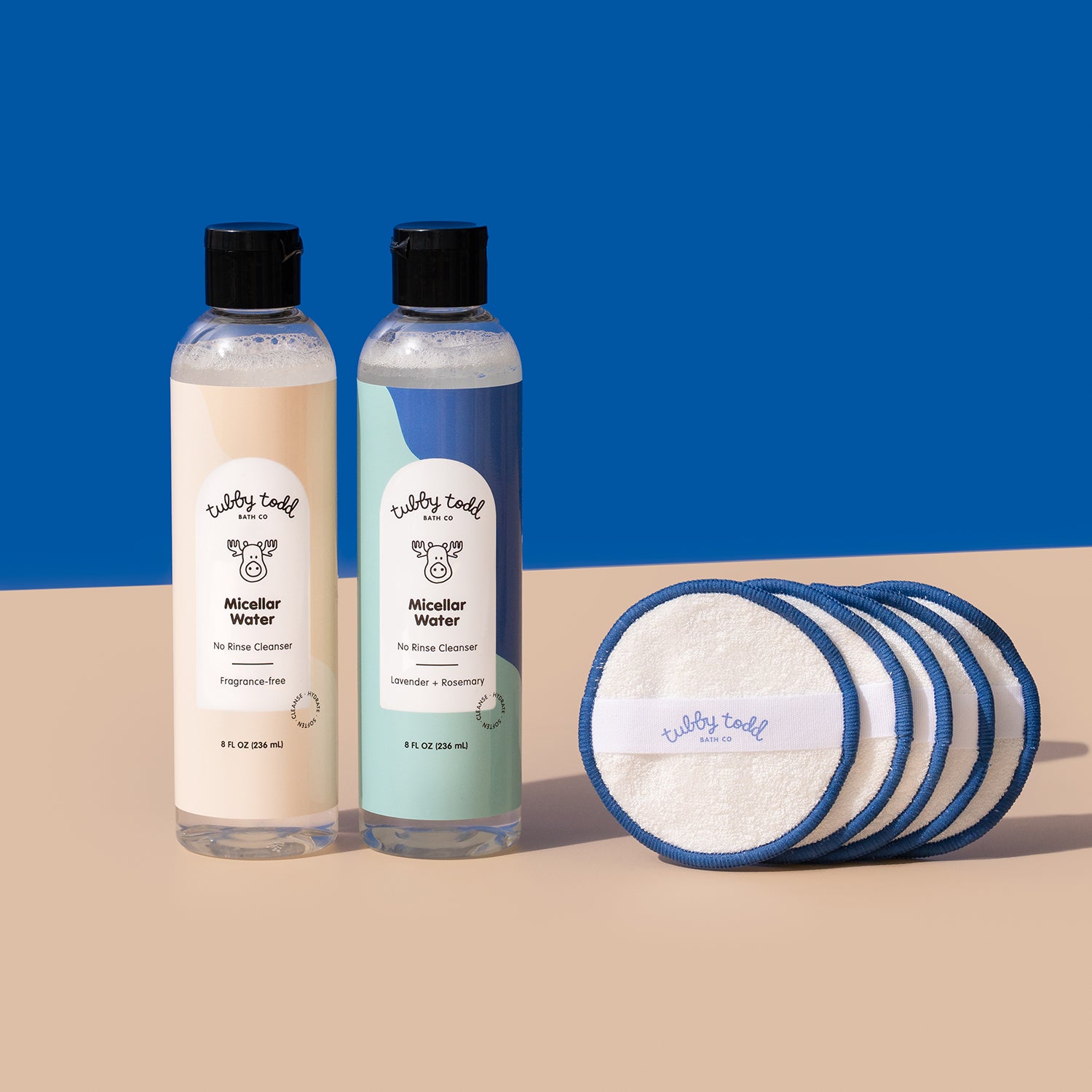 Fragrance Free, Lavender Rosemary Micellar Water bottles, and the cotton pads are standing on the blue and beige color block background.